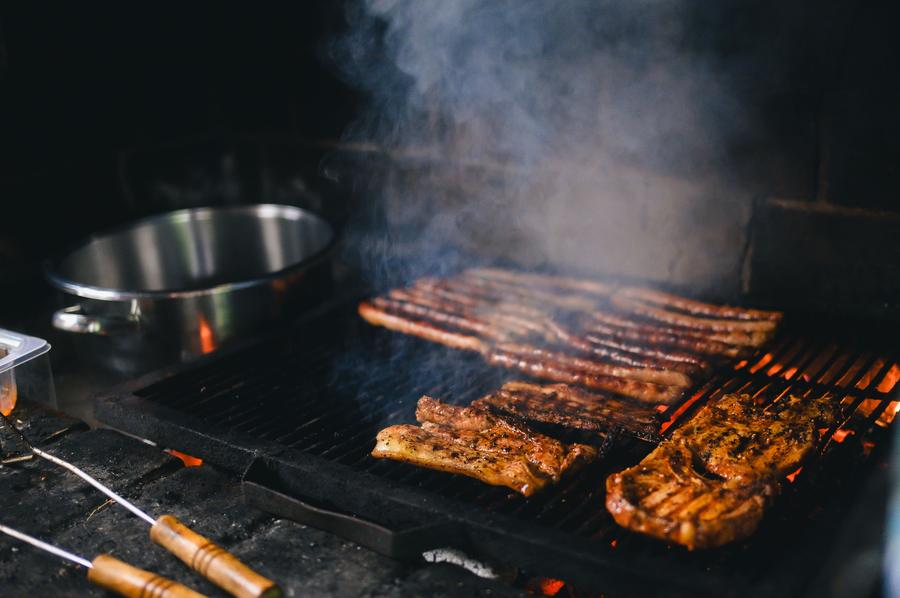 Steaks grilling on a braai fire