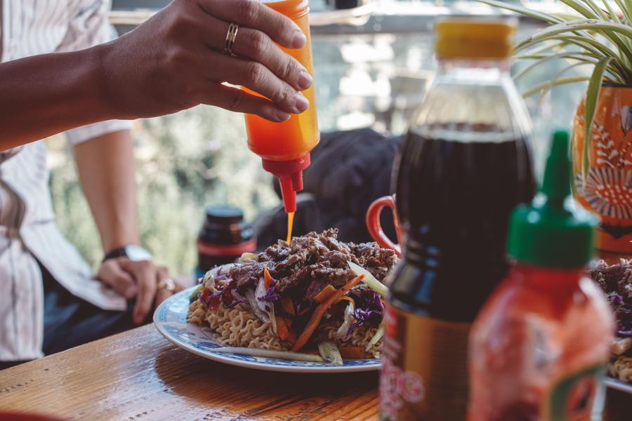 Sauce being poured over grilled food